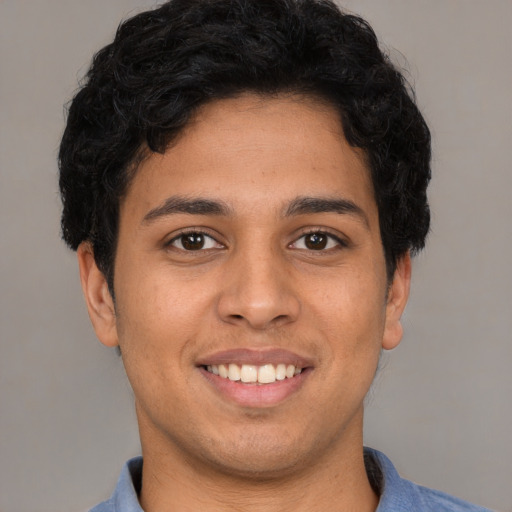 Joyful latino young-adult male with short  brown hair and brown eyes