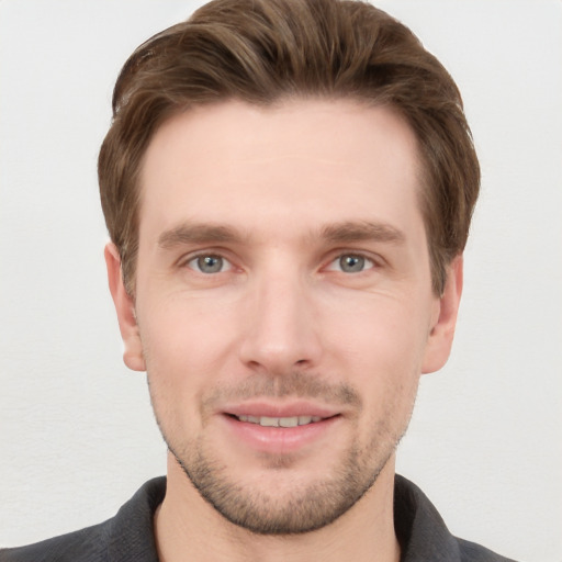 Joyful white young-adult male with short  brown hair and grey eyes