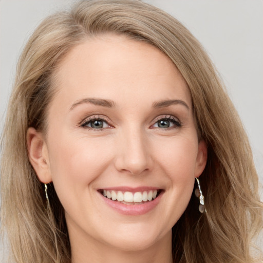 Joyful white young-adult female with long  brown hair and blue eyes