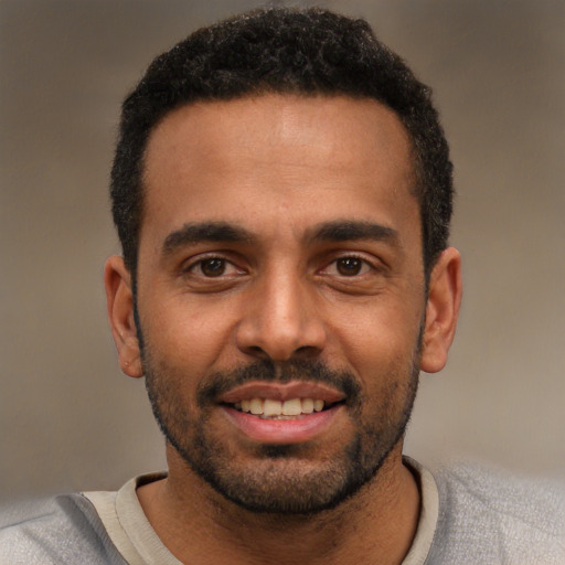 Joyful black young-adult male with short  black hair and brown eyes