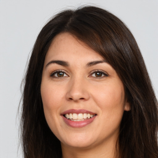 Joyful white young-adult female with long  brown hair and brown eyes