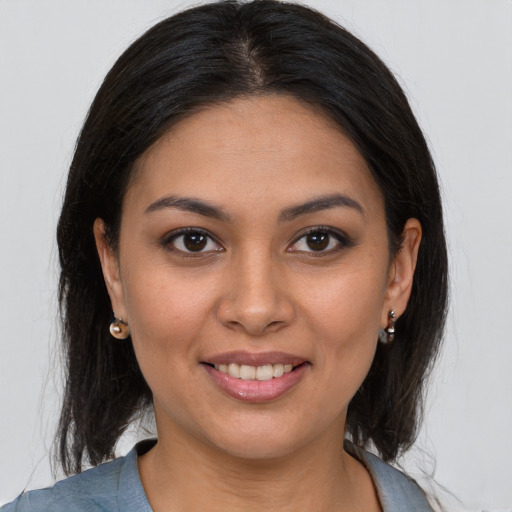 Joyful latino young-adult female with medium  brown hair and brown eyes