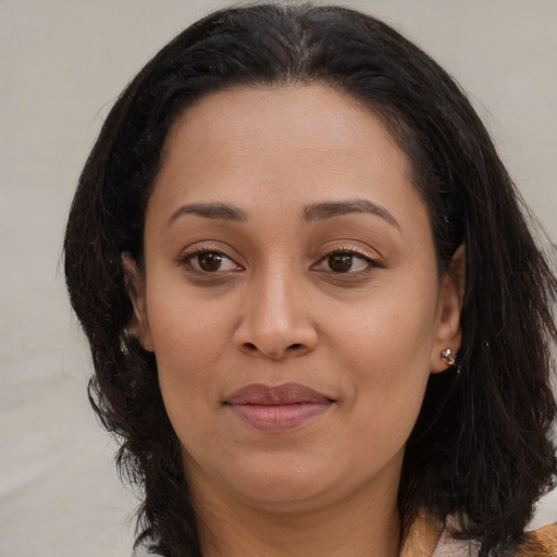 Joyful latino young-adult female with medium  brown hair and brown eyes