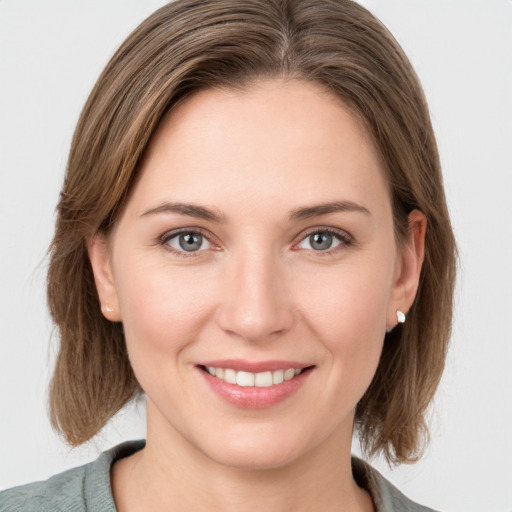 Joyful white young-adult female with medium  brown hair and grey eyes