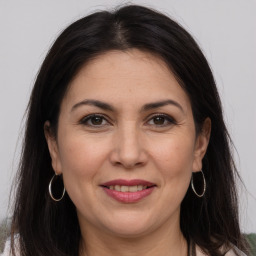 Joyful white adult female with long  brown hair and brown eyes