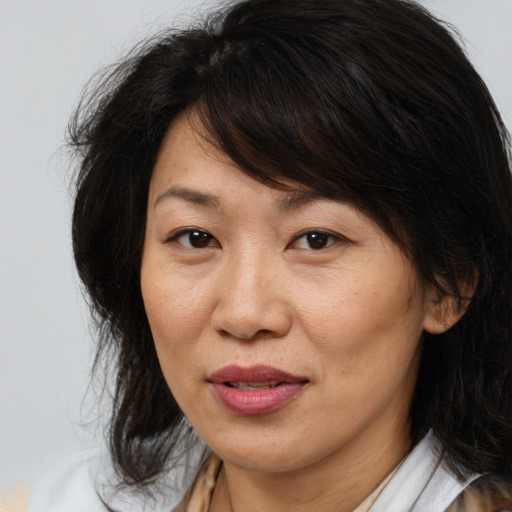 Joyful asian adult female with medium  brown hair and brown eyes