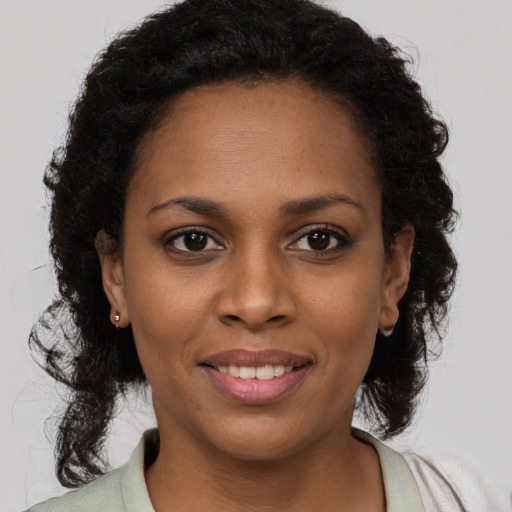 Joyful black young-adult female with medium  brown hair and brown eyes
