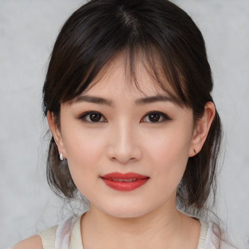 Joyful asian young-adult female with medium  brown hair and brown eyes
