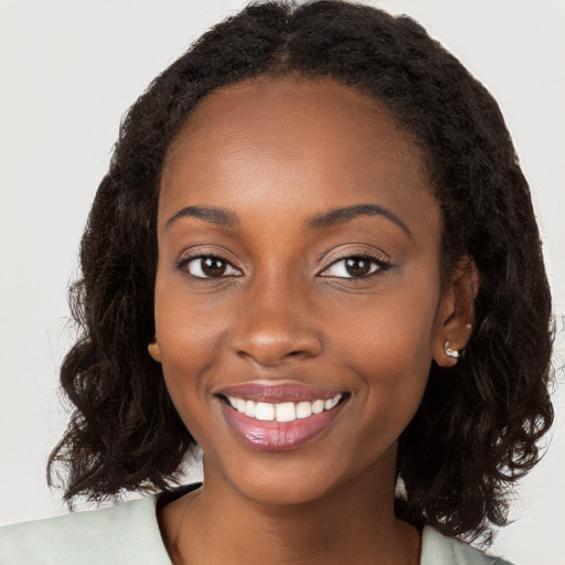 Joyful black young-adult female with long  brown hair and brown eyes