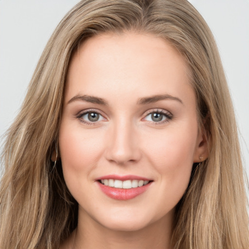 Joyful white young-adult female with long  brown hair and grey eyes