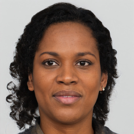 Joyful black adult female with long  black hair and brown eyes