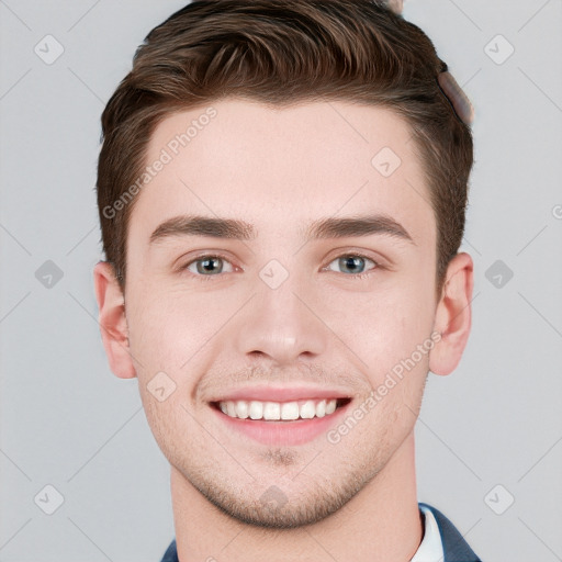 Joyful white young-adult male with short  brown hair and grey eyes