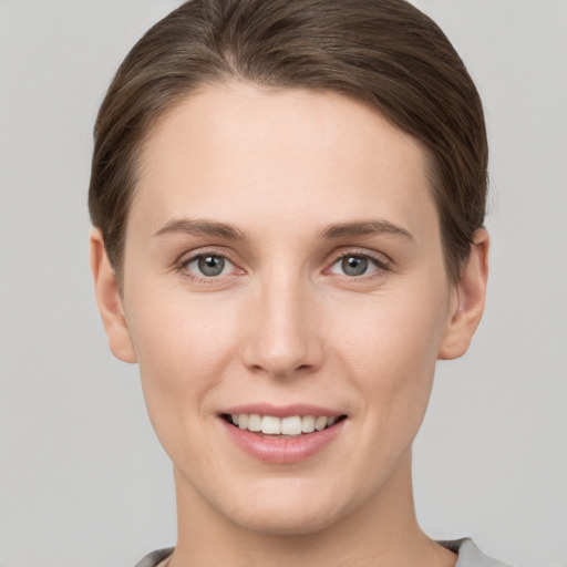 Joyful white young-adult female with short  brown hair and grey eyes