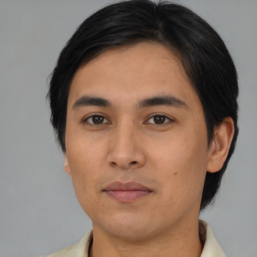 Joyful asian young-adult male with medium  brown hair and brown eyes