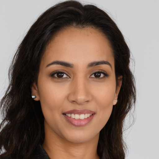 Joyful latino young-adult female with long  brown hair and brown eyes