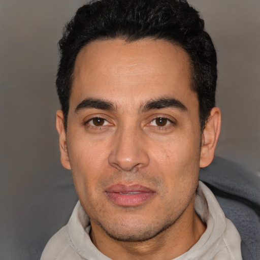 Joyful white young-adult male with short  black hair and brown eyes