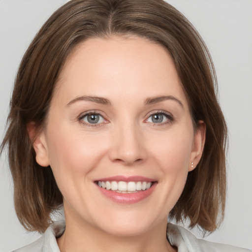 Joyful white young-adult female with medium  brown hair and grey eyes