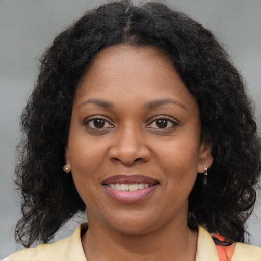 Joyful black young-adult female with medium  brown hair and brown eyes