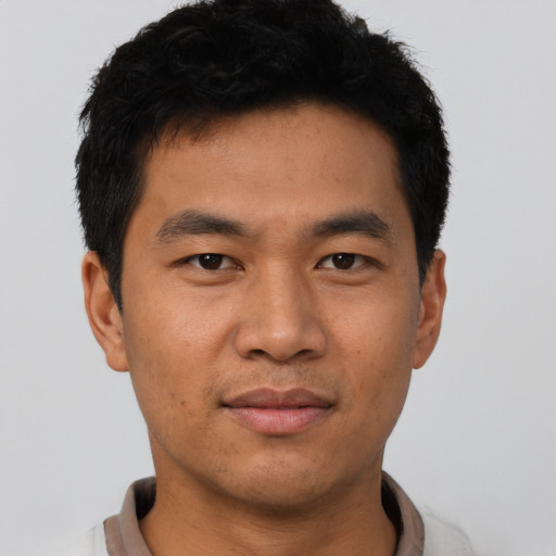 Joyful asian young-adult male with short  black hair and brown eyes