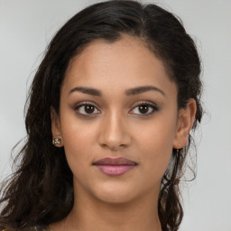 Joyful latino young-adult female with long  brown hair and brown eyes