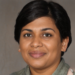 Joyful black adult female with medium  brown hair and brown eyes