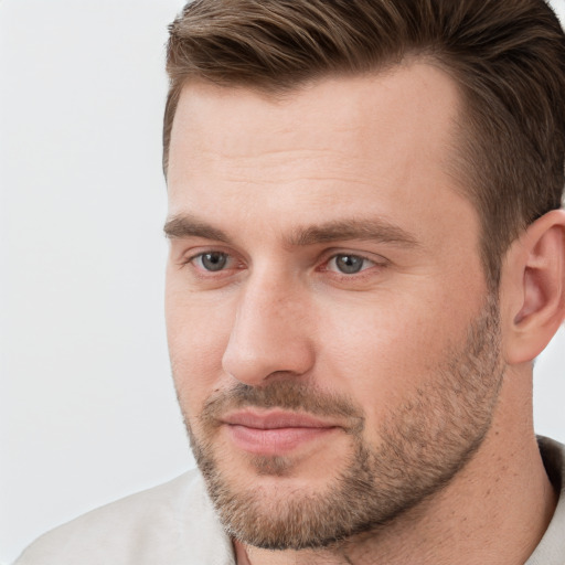 Joyful white young-adult male with short  brown hair and grey eyes