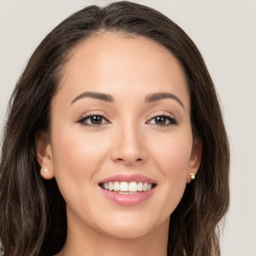 Joyful white young-adult female with long  brown hair and brown eyes