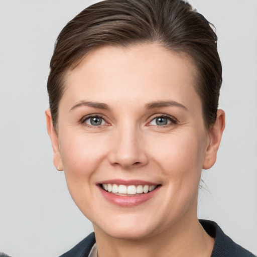 Joyful white young-adult female with short  brown hair and grey eyes