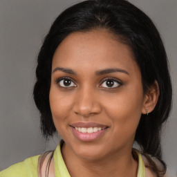 Joyful black young-adult female with medium  brown hair and brown eyes