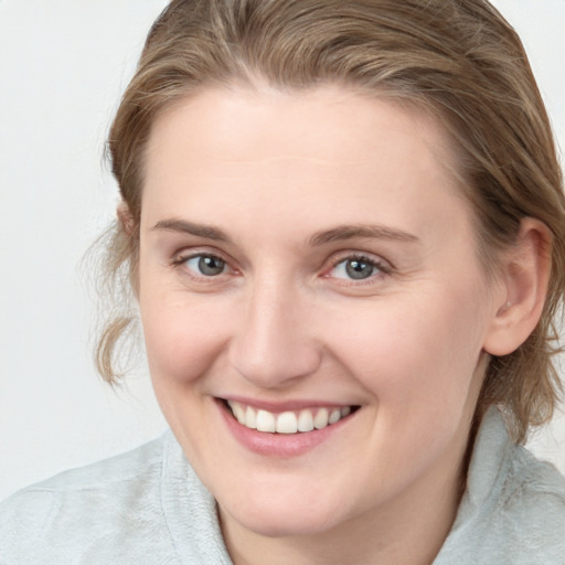 Joyful white young-adult female with medium  brown hair and blue eyes