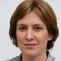 Joyful white adult female with medium  brown hair and grey eyes