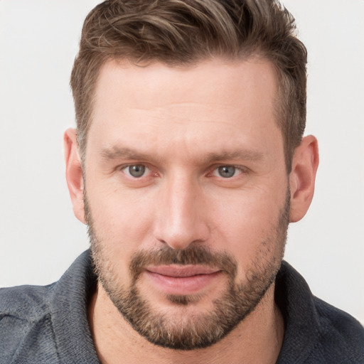 Joyful white young-adult male with short  brown hair and blue eyes