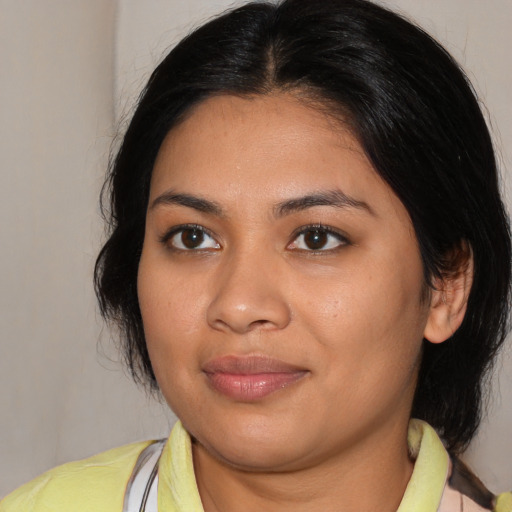 Joyful latino young-adult female with medium  brown hair and brown eyes