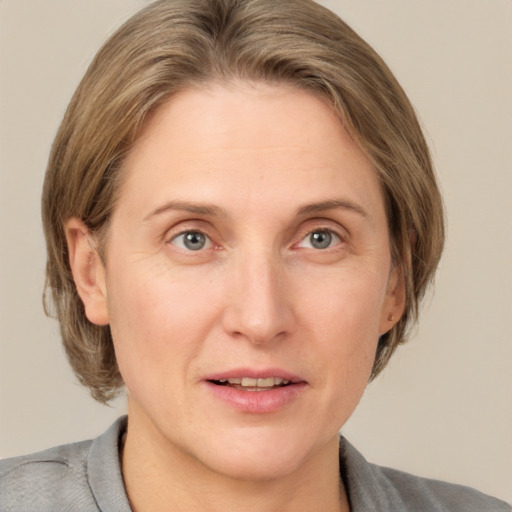 Joyful white adult female with medium  brown hair and grey eyes