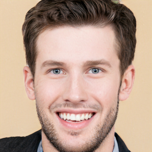 Joyful white young-adult male with short  brown hair and grey eyes