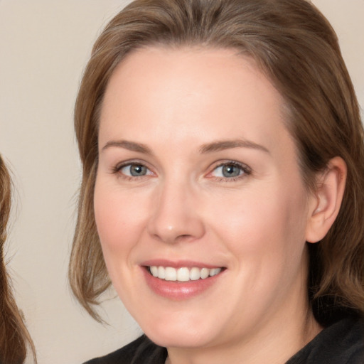 Joyful white adult female with long  brown hair and brown eyes