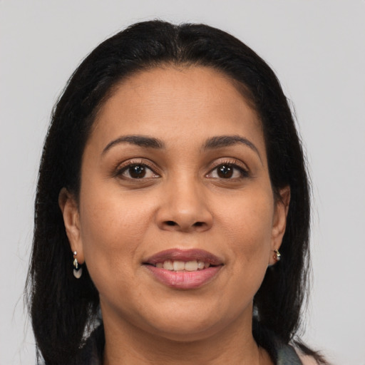 Joyful latino young-adult female with medium  brown hair and brown eyes