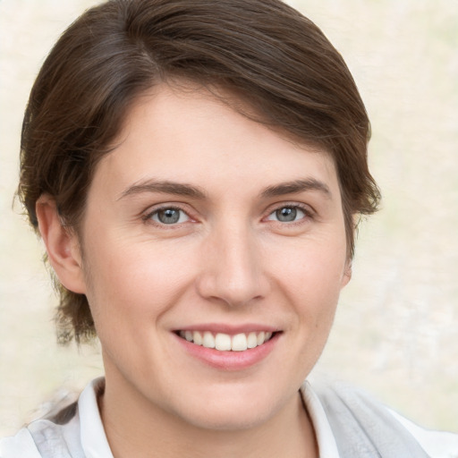 Joyful white young-adult female with medium  brown hair and grey eyes