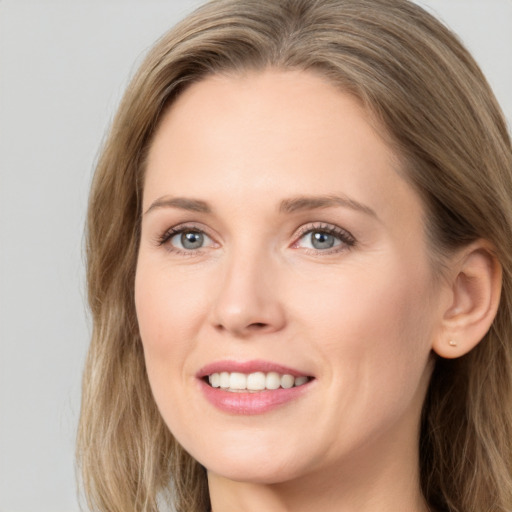 Joyful white young-adult female with long  brown hair and grey eyes