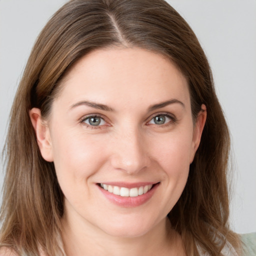 Joyful white young-adult female with long  brown hair and grey eyes