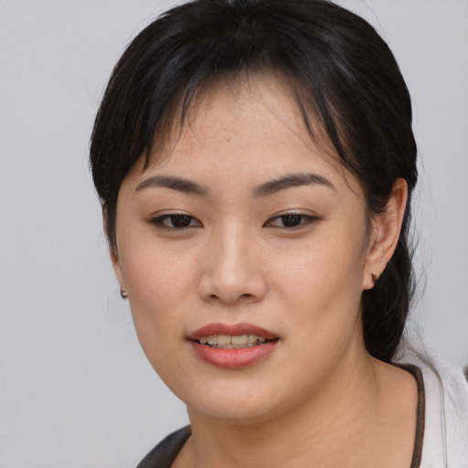 Joyful asian young-adult female with medium  brown hair and brown eyes