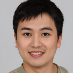 Joyful asian young-adult male with short  brown hair and brown eyes