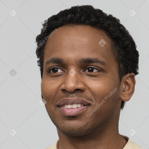 Joyful black young-adult male with short  black hair and brown eyes