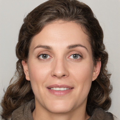 Joyful white young-adult female with medium  brown hair and green eyes