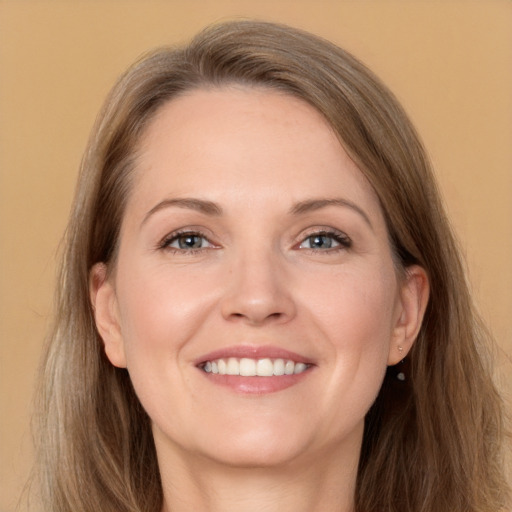 Joyful white adult female with long  brown hair and grey eyes