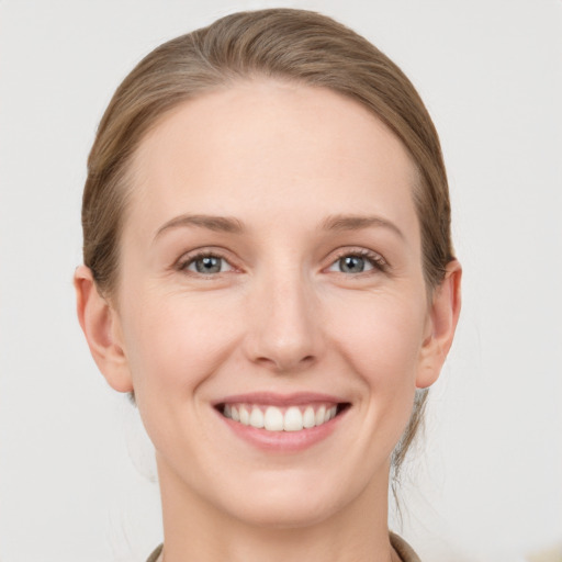 Joyful white young-adult female with medium  brown hair and grey eyes