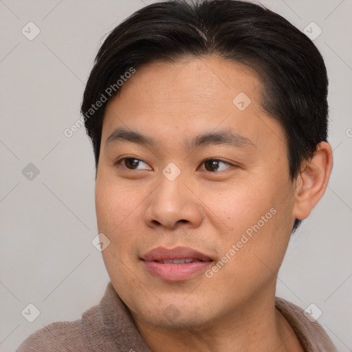 Joyful asian young-adult male with short  brown hair and brown eyes