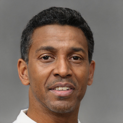 Joyful black adult male with short  black hair and brown eyes