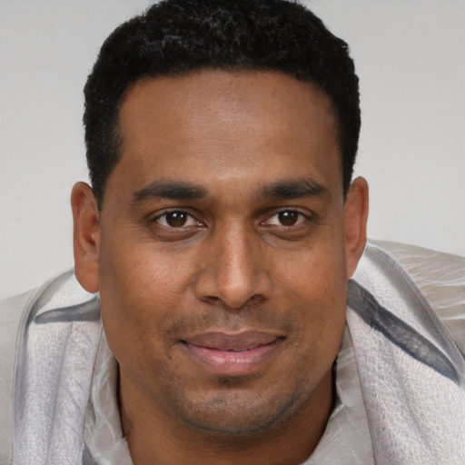 Joyful black young-adult male with short  brown hair and brown eyes