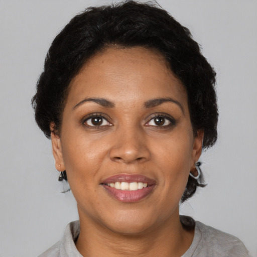 Joyful black young-adult female with short  black hair and brown eyes
